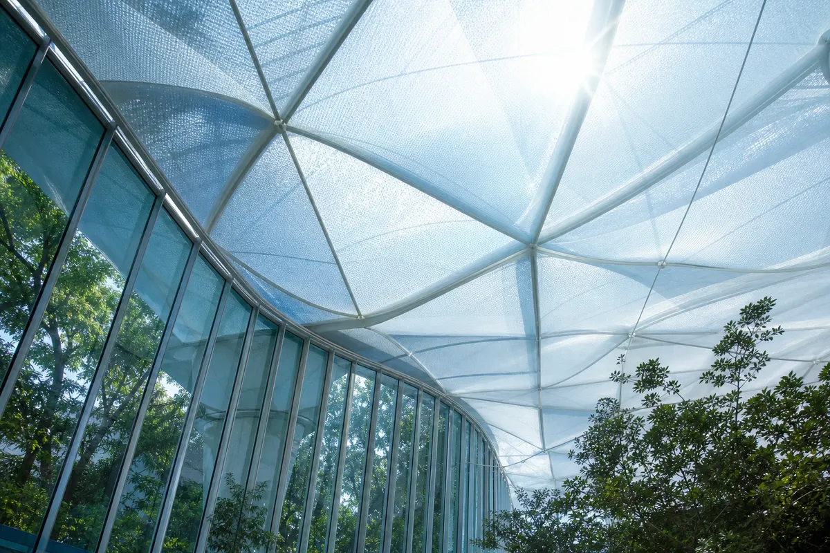 Layered translucent ETFE cushions filtering soft daylight in a calm architectural interior