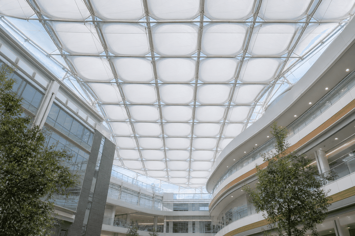 Hospital atrium interior looking up at a daylit ETFE cushion roof