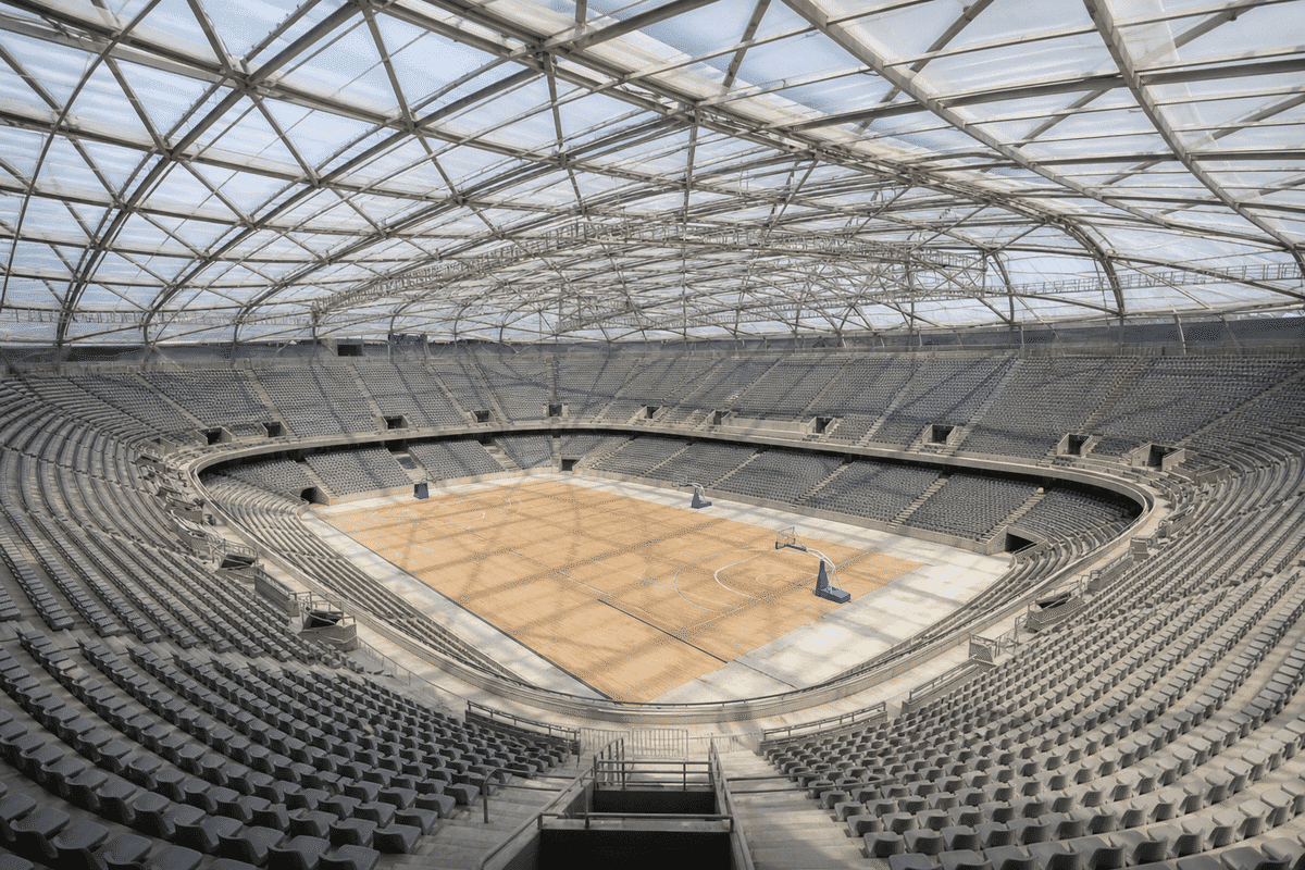 Natural daylight washing an indoor sports arena bowl through an ETFE roof