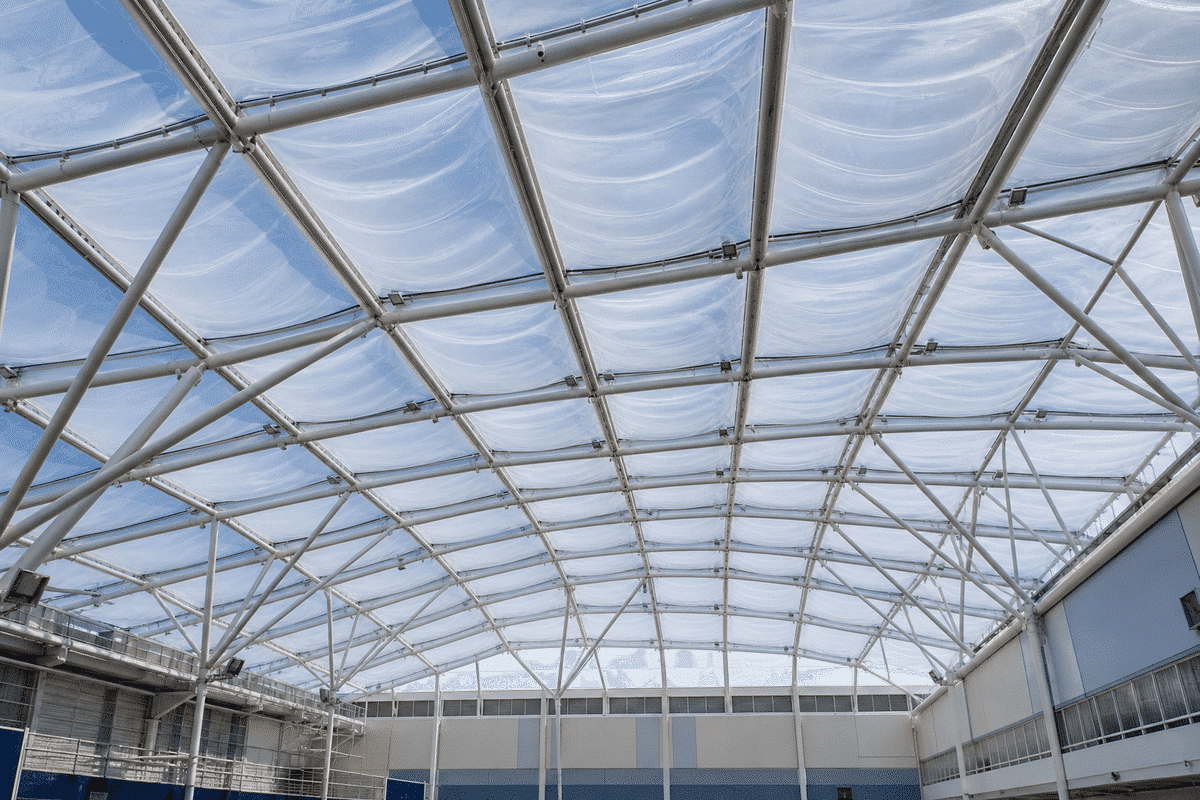 Interior looking up at a daylit ETFE cushion roof in a modern sports complex with ETFE roof