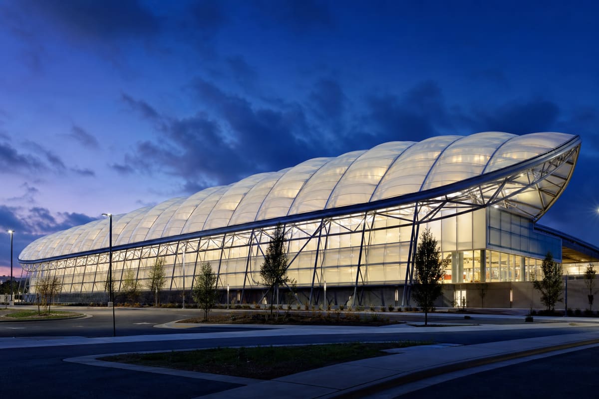 Contemporary ETFE-clad architectural structure illuminated at dusk