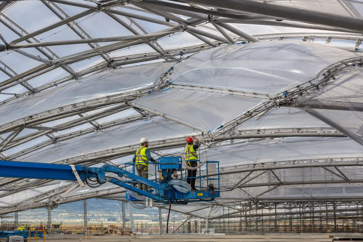 Daylit airport concourse beneath a translucent multi-layer ETFE cushion roof