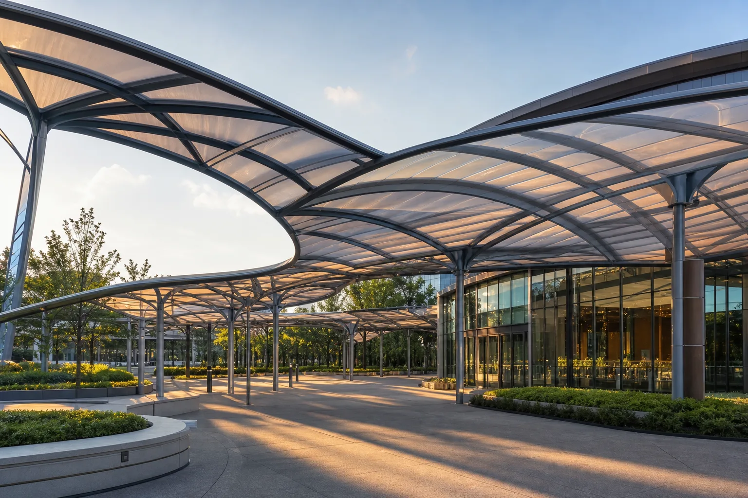 Transparent ETFE entrance canopy over a modern building façade in golden hour light