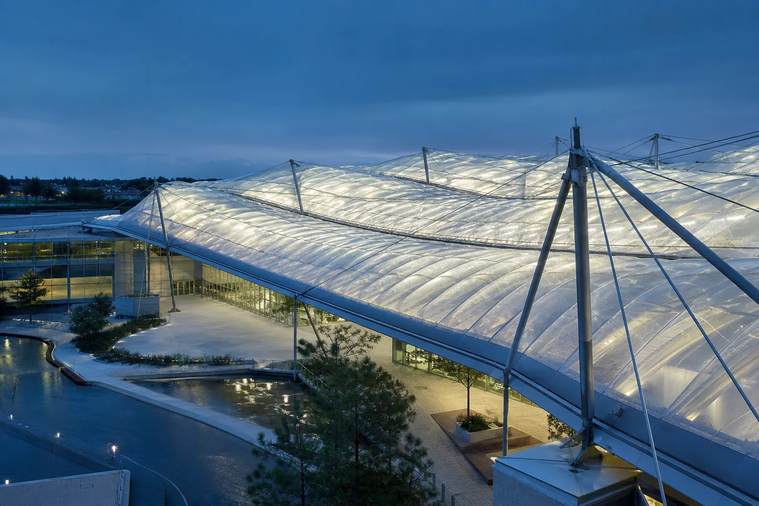 Luminous ETFE air cushion roof over a contemporary research pavilion at blue hour