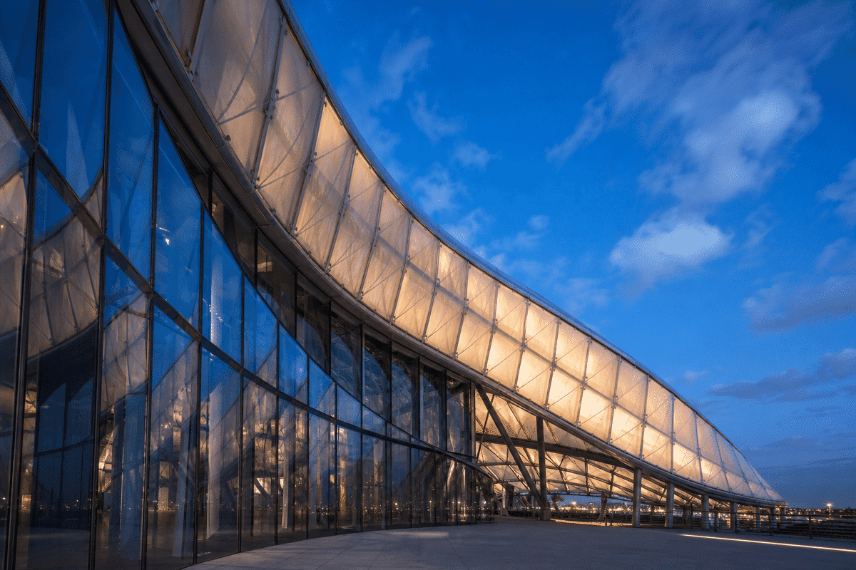 Cultural center ETFE roof beside reflective glass tower